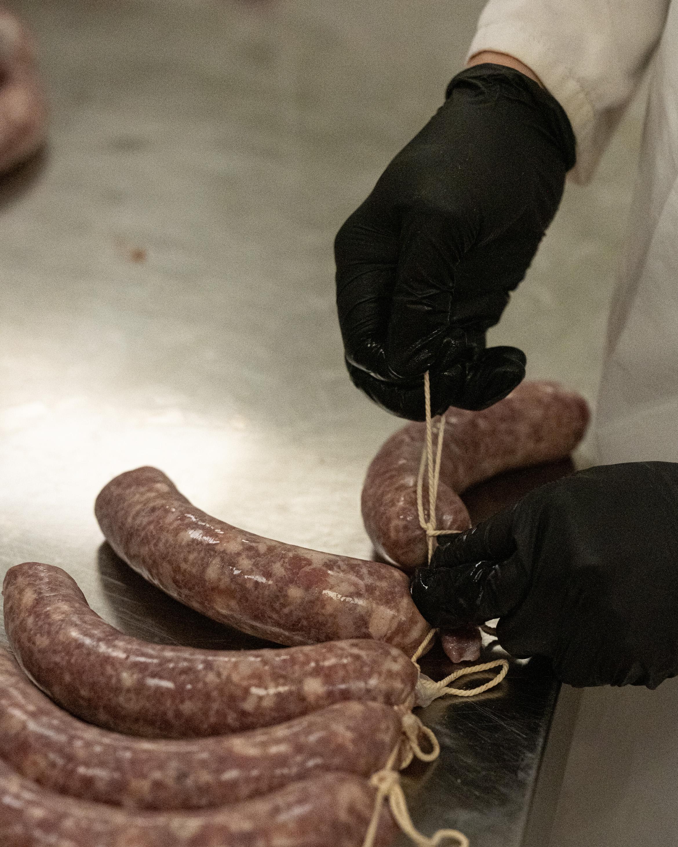 Een van de professionele droogkasten, zelfs het knopen gebeurt met de hand, Vitadella, Cordemijers versie van de mortadella